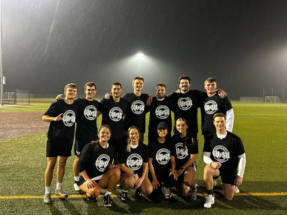 Students wearing championship shirts from a coed flag football tournament